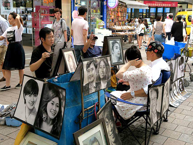 Dessinateurs de rue à Myeongdong, Seoul.